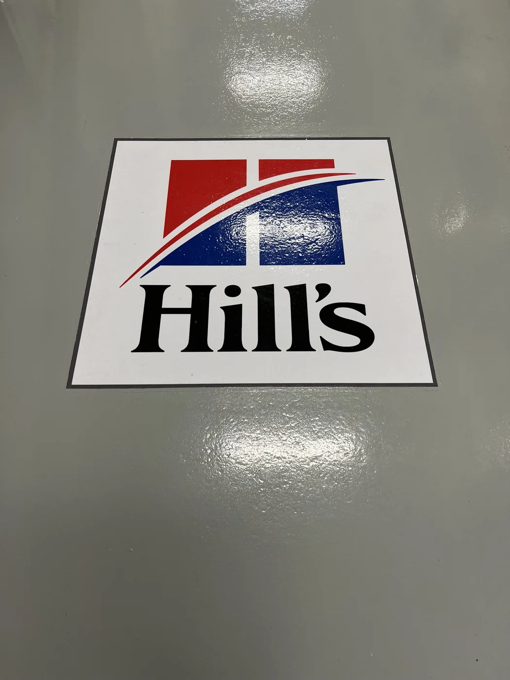 Company logo inlaid into a grey epoxy floor coating with a high gloss finish