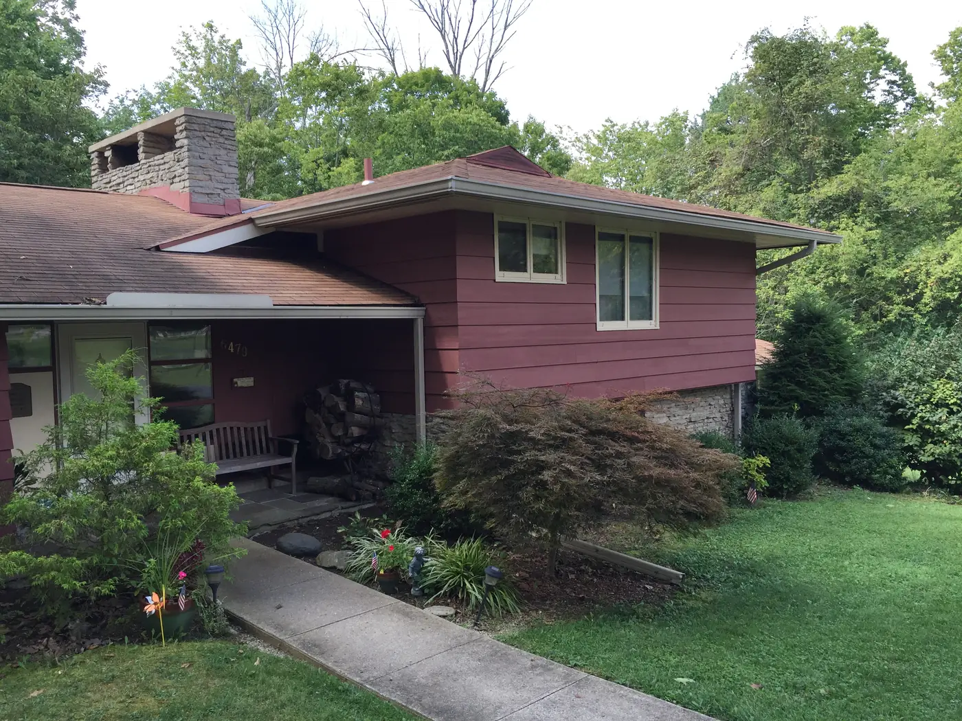 Split level ranch home painted a deep rose color with white window trim