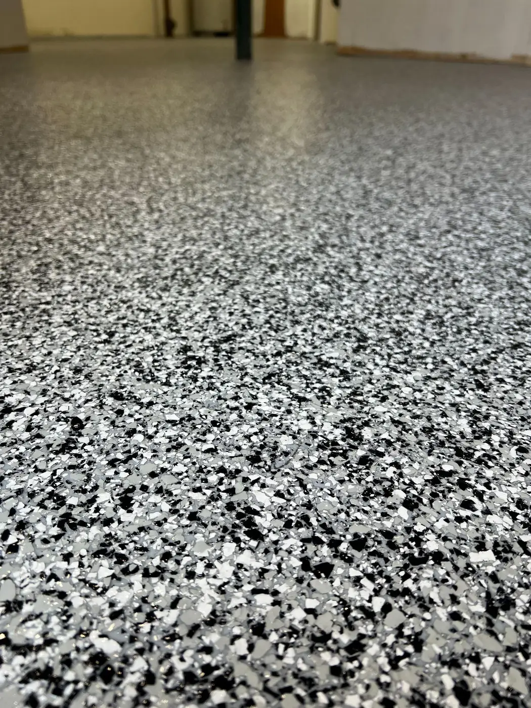 Close up of a black, white and grey flake floor coating