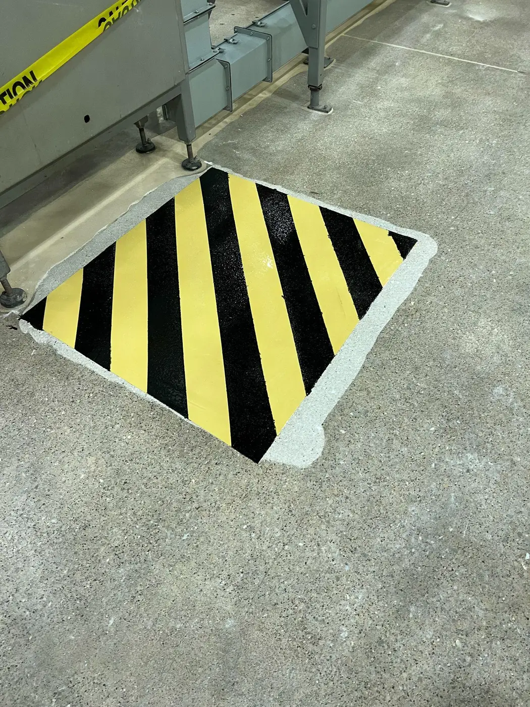 Yellow and black safety striping marked onto a concrete plant floor