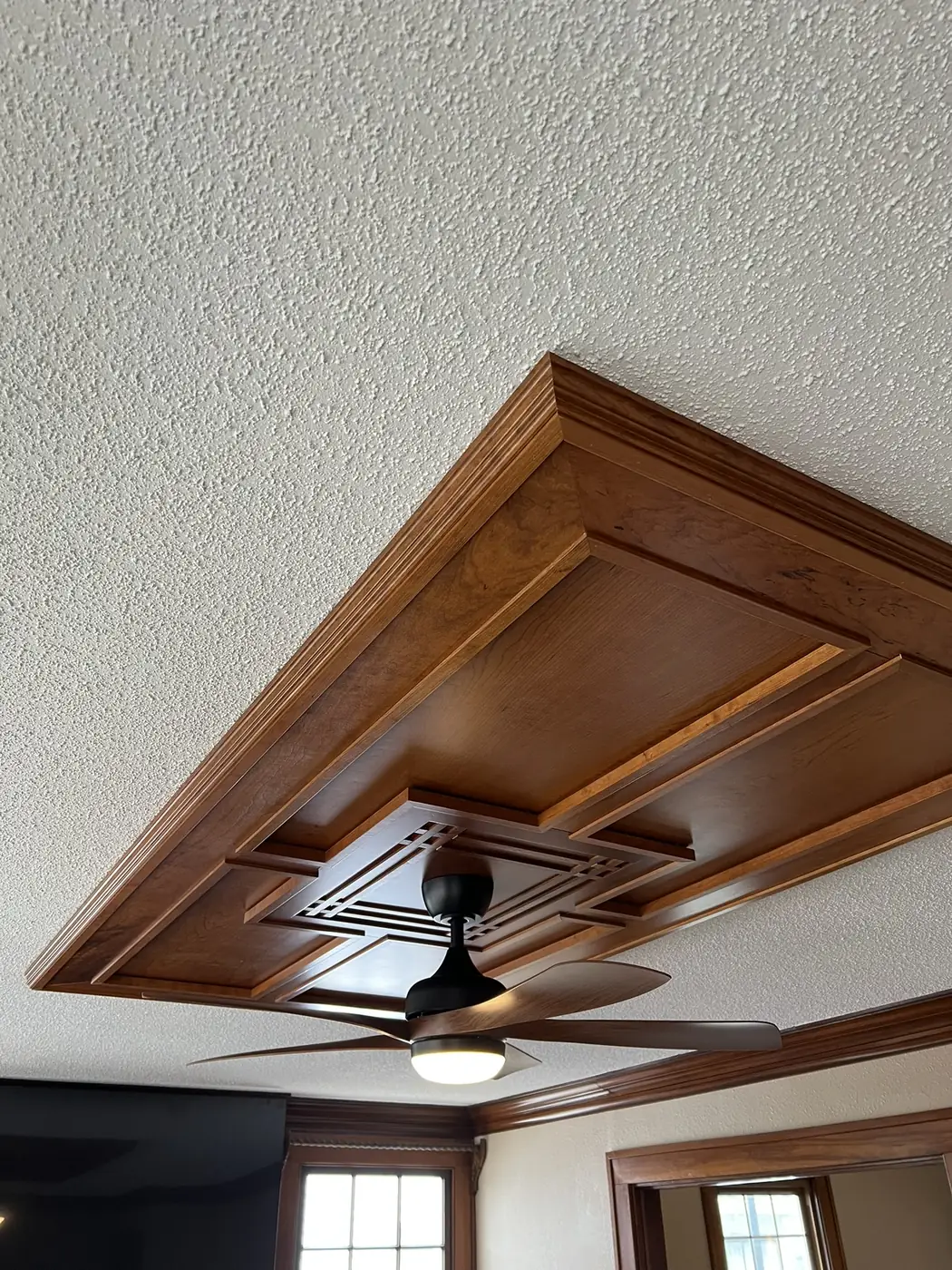 Close up of a stained wood coffered ceiling detail and the painted ceiling around it