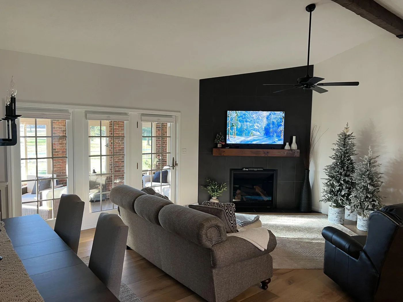 Living room with pale painted walls, a dark fireplace surround and french doors